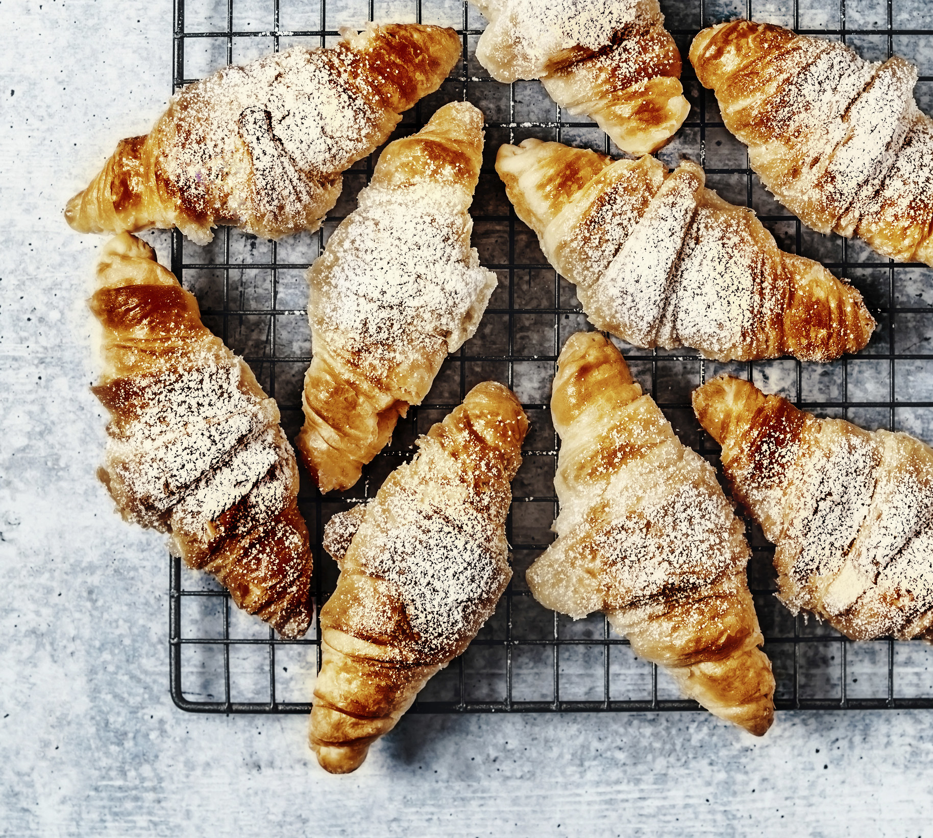 tray of croissants with powdered sugar
