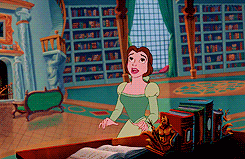 Belle, next to the beast, looks up in awe at the massive bookshelves of his library