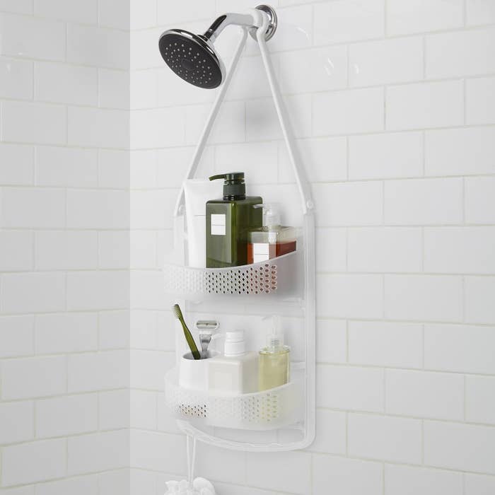 A shower caddy hanging from the shower head