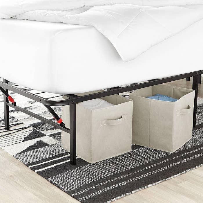 White foldable storage cubes stowed under a bed