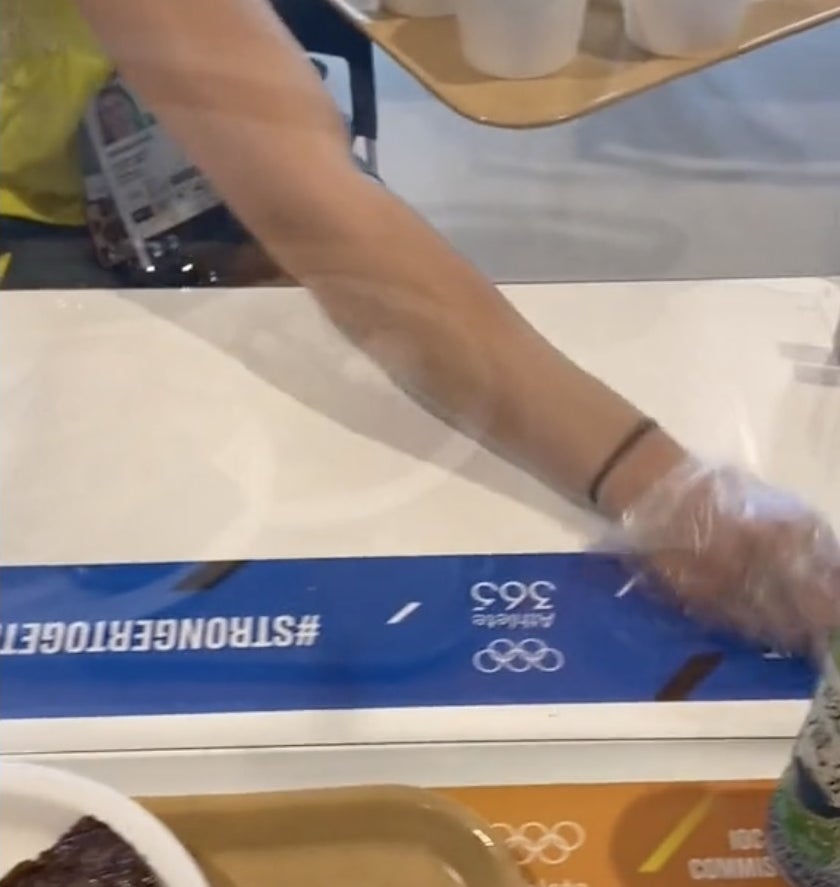 An athlete wipes her table clean while wearing a glove