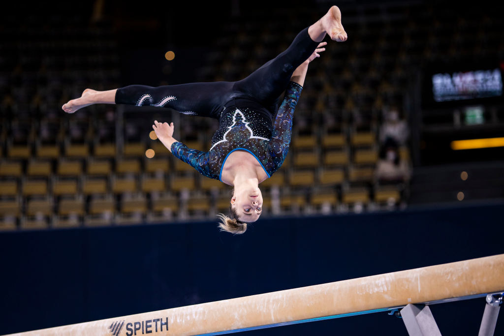 Carina Kröll wear a unitard while competing on beam