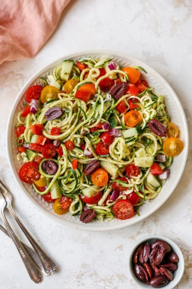 A bowl of spiralized zucchini, carrots, and olives