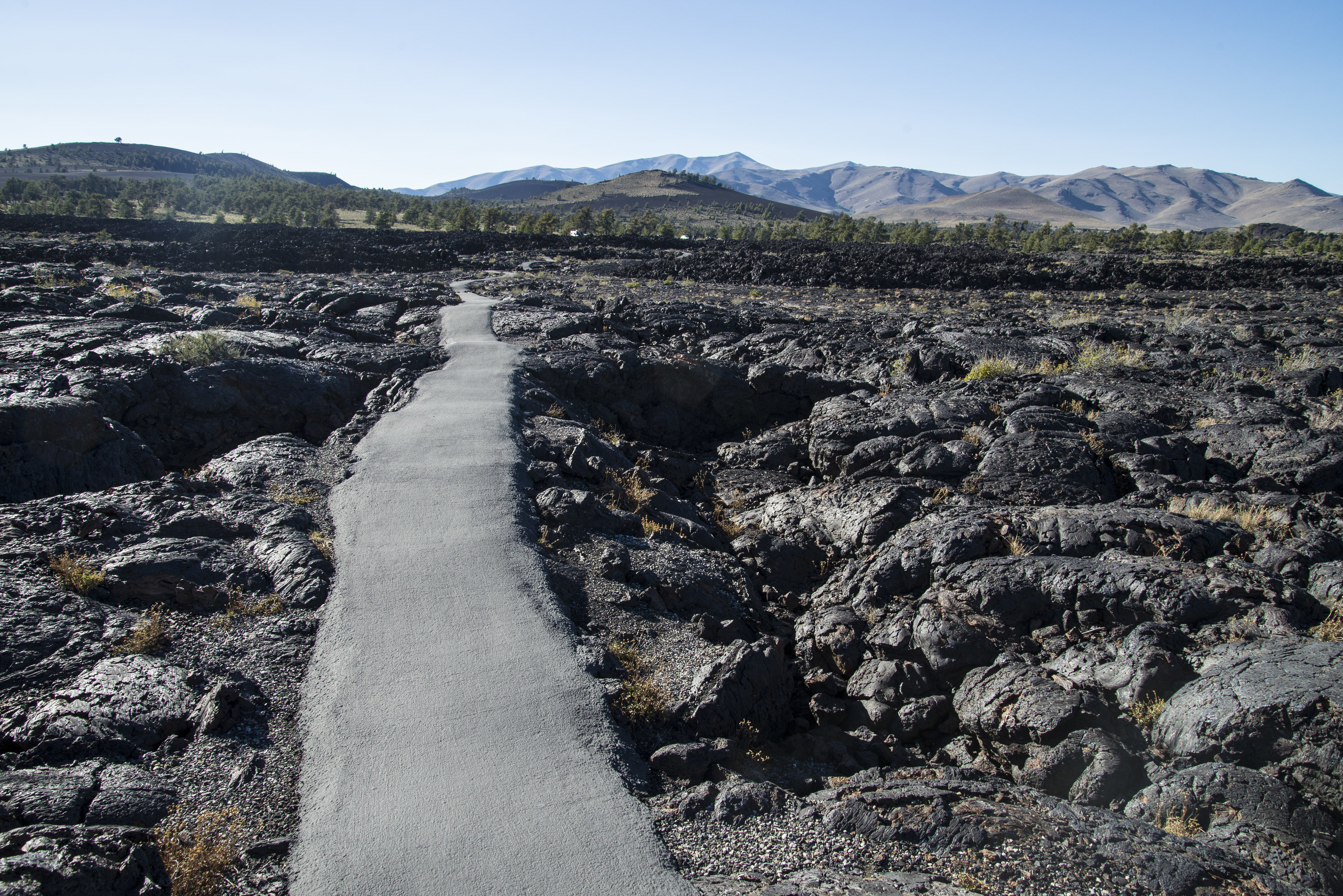 Artificial walkway cuts through lumpy, dark lava formations of the Craters of the Moon monument