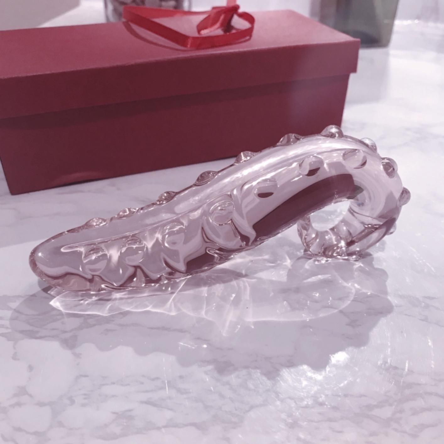 Pink detailed tentacle glass dildo next to box