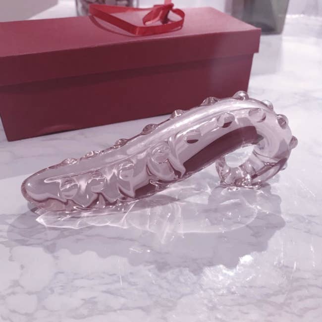 Pink elaborate  tentacle solid  dildo adjacent  to box