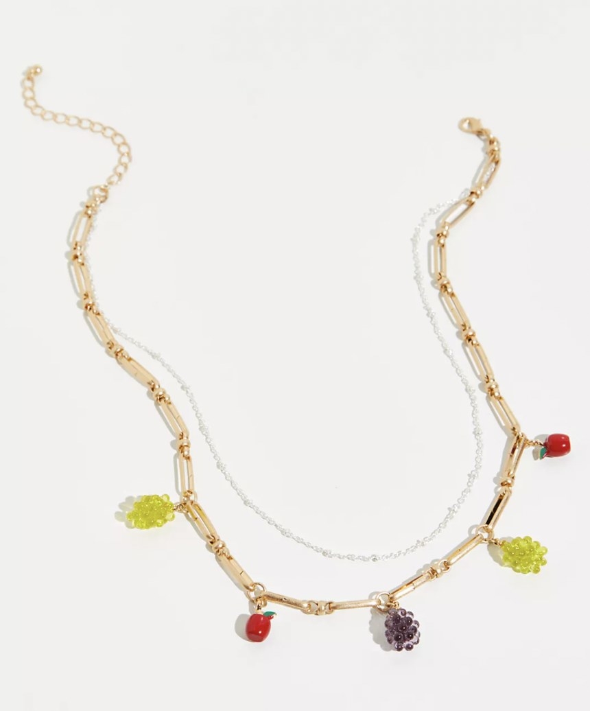 a gold chain necklace with fruits on it