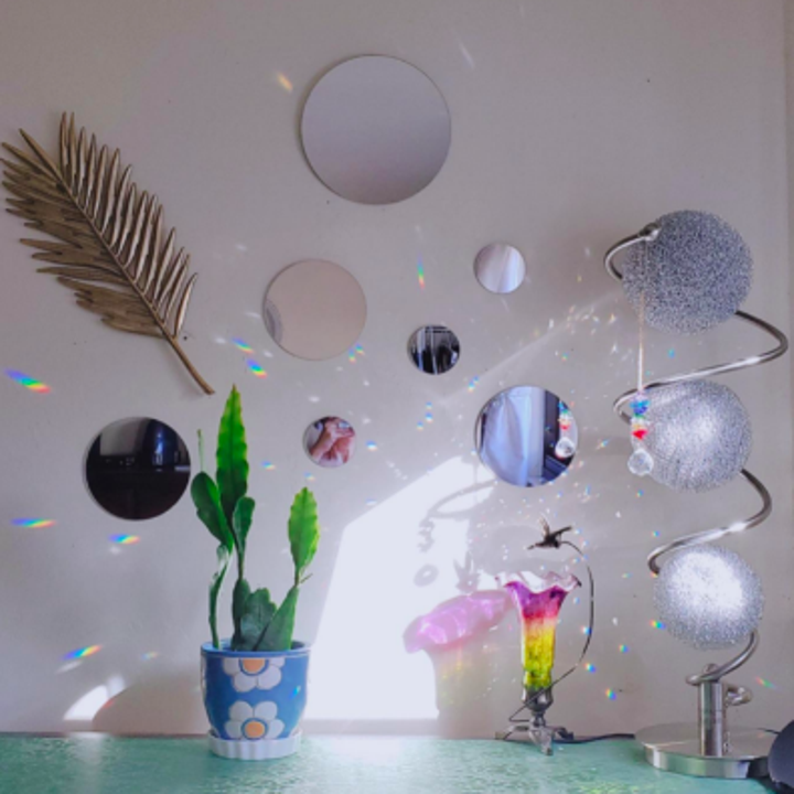 reviewer's dresser with round mirrors above vanity beside disco ball decor, bouncing rainbows where hitting the light 