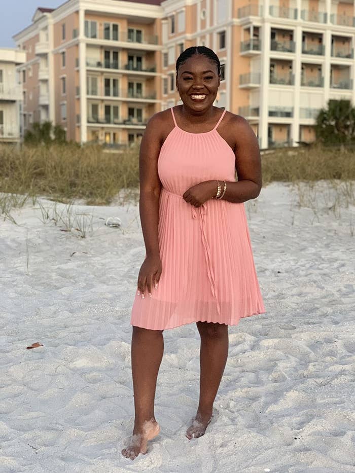 image of reviewer wearing the blush pink pleated dress on the beach