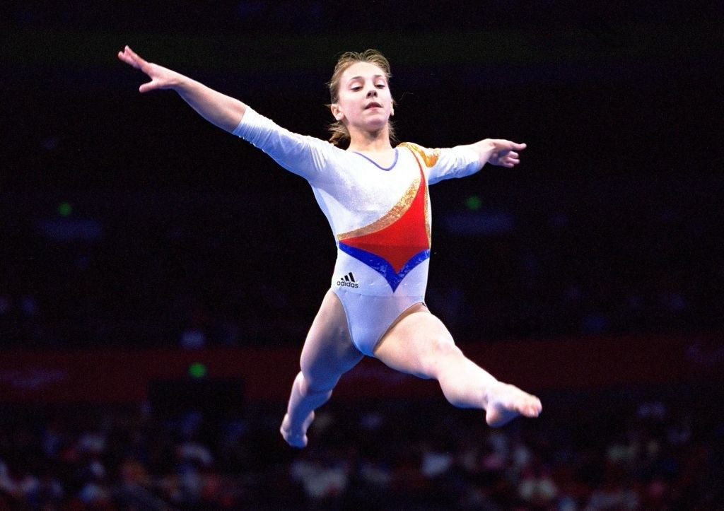 Andreea Răducan jumping mid air in her gymnastics routine at the 2000 olympics