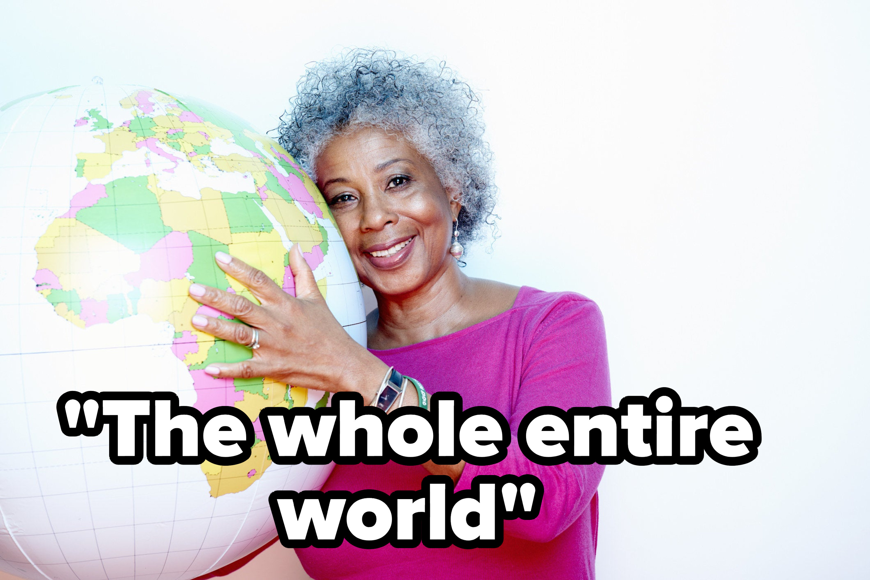 A smiling woman holding a globe with the caption &quot;The whole entire world&quot;