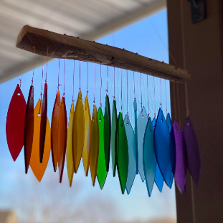 rainbow glass feathers hung from a natural wood stick 