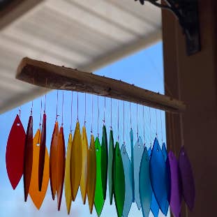 rainbow glass feathers hung from a natural wood stick 