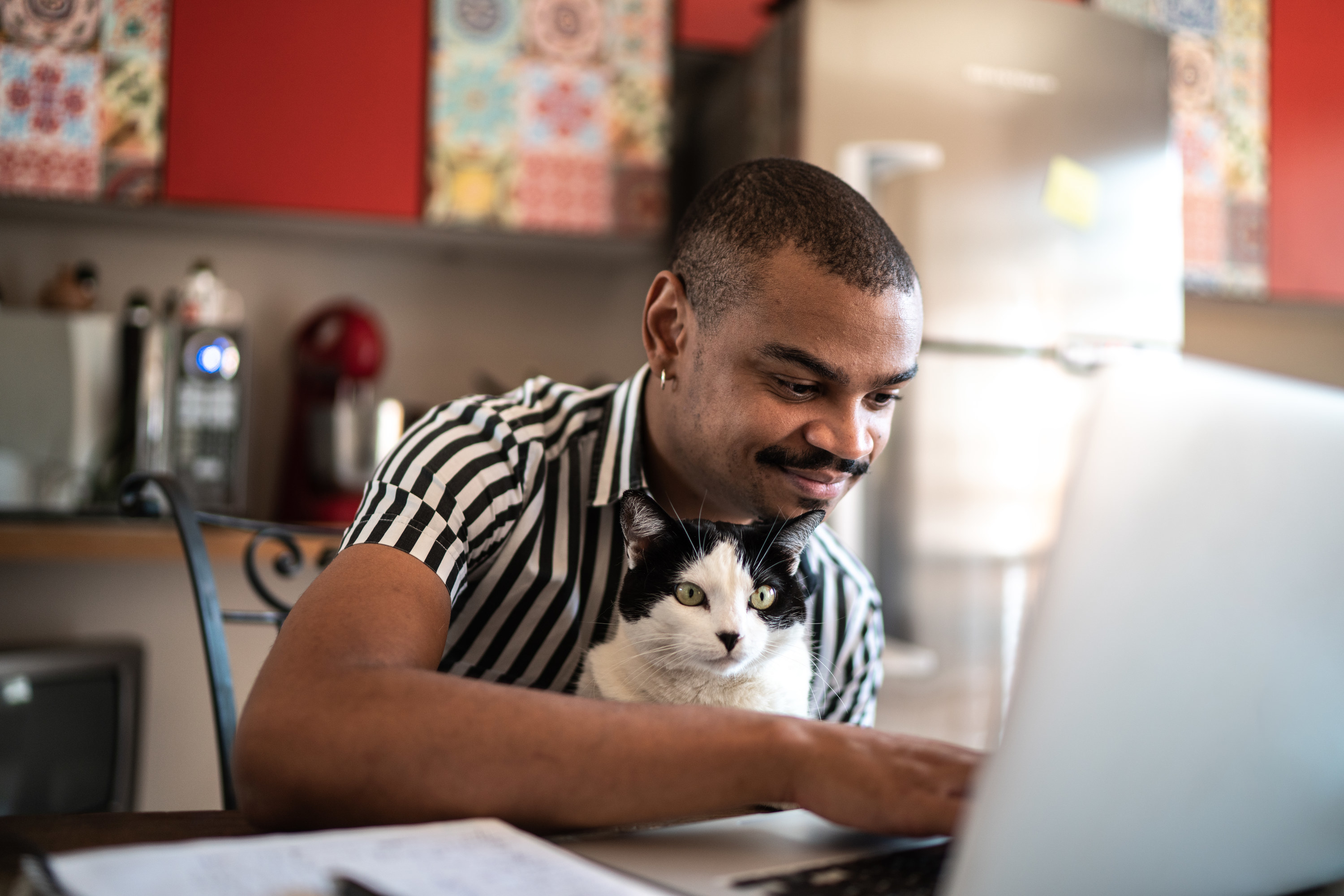 Man working from home with a cat in his lap