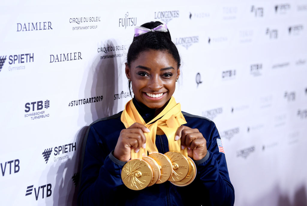 Simone on a red carpet with her gold medals