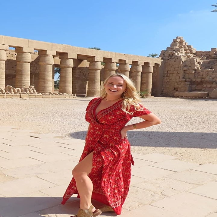 image of reviewer posing in the red wrap maxi dress in a size small outside of Roman ruins