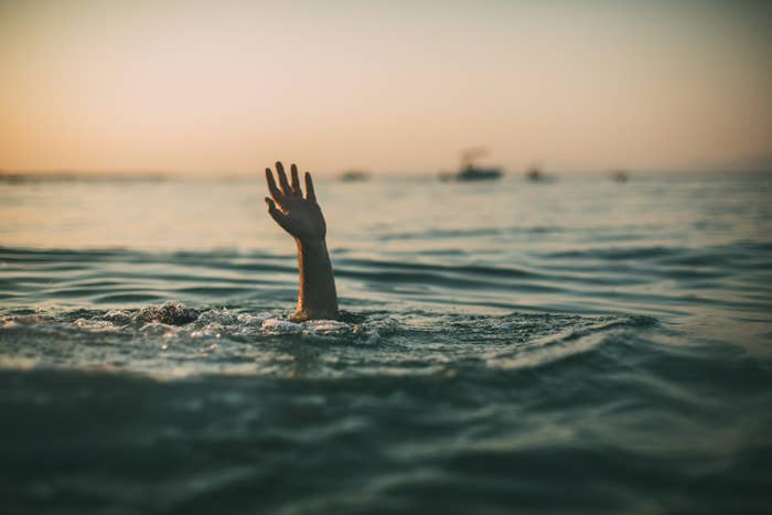 A person reaching their hand above water for help