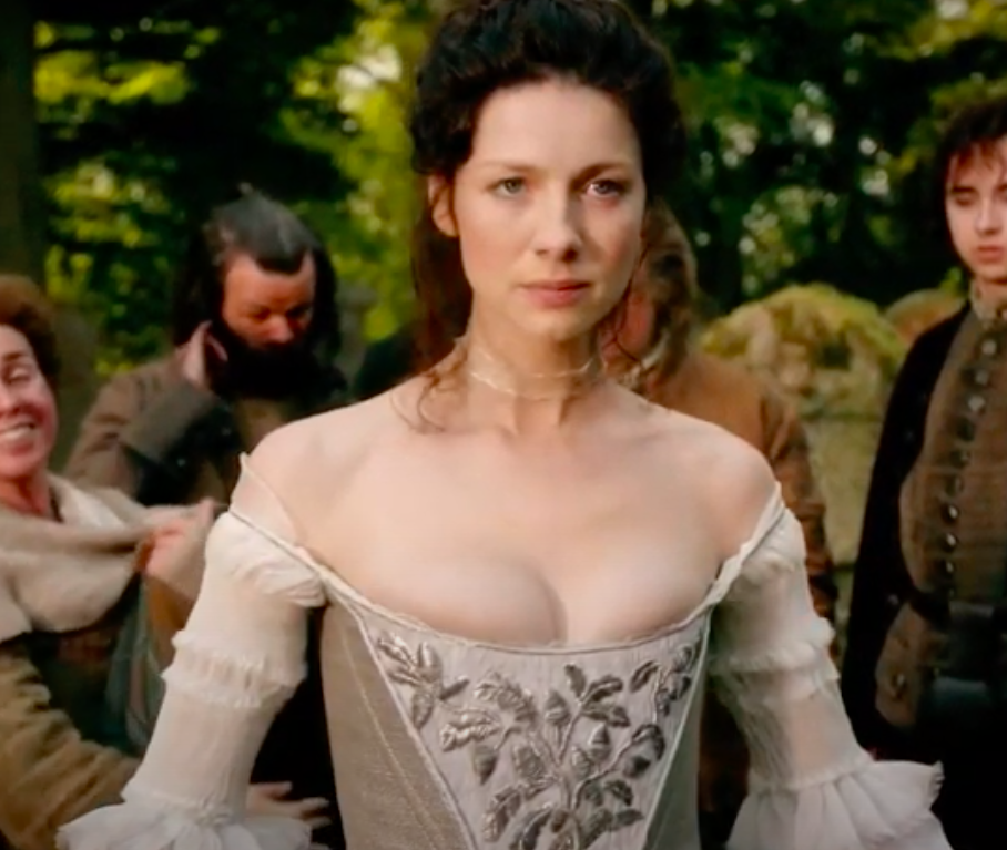 Claire wearing a ballgown dress with a corset and long sleeves
