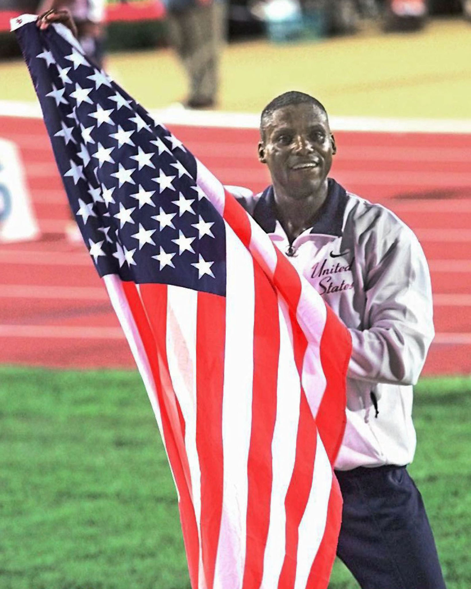 Carl Lewis celebrates with an American flag