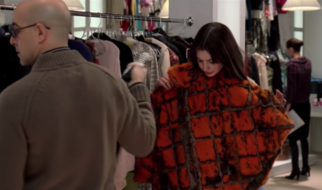 Nigel handing Andie an orange poncho