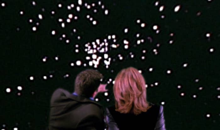 Ross points out star constellations on a projected screen for Rachel