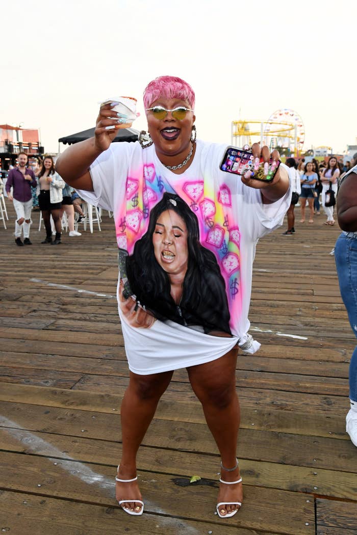 Lizzo smiling while rocking a spray-painted T-shirt dress