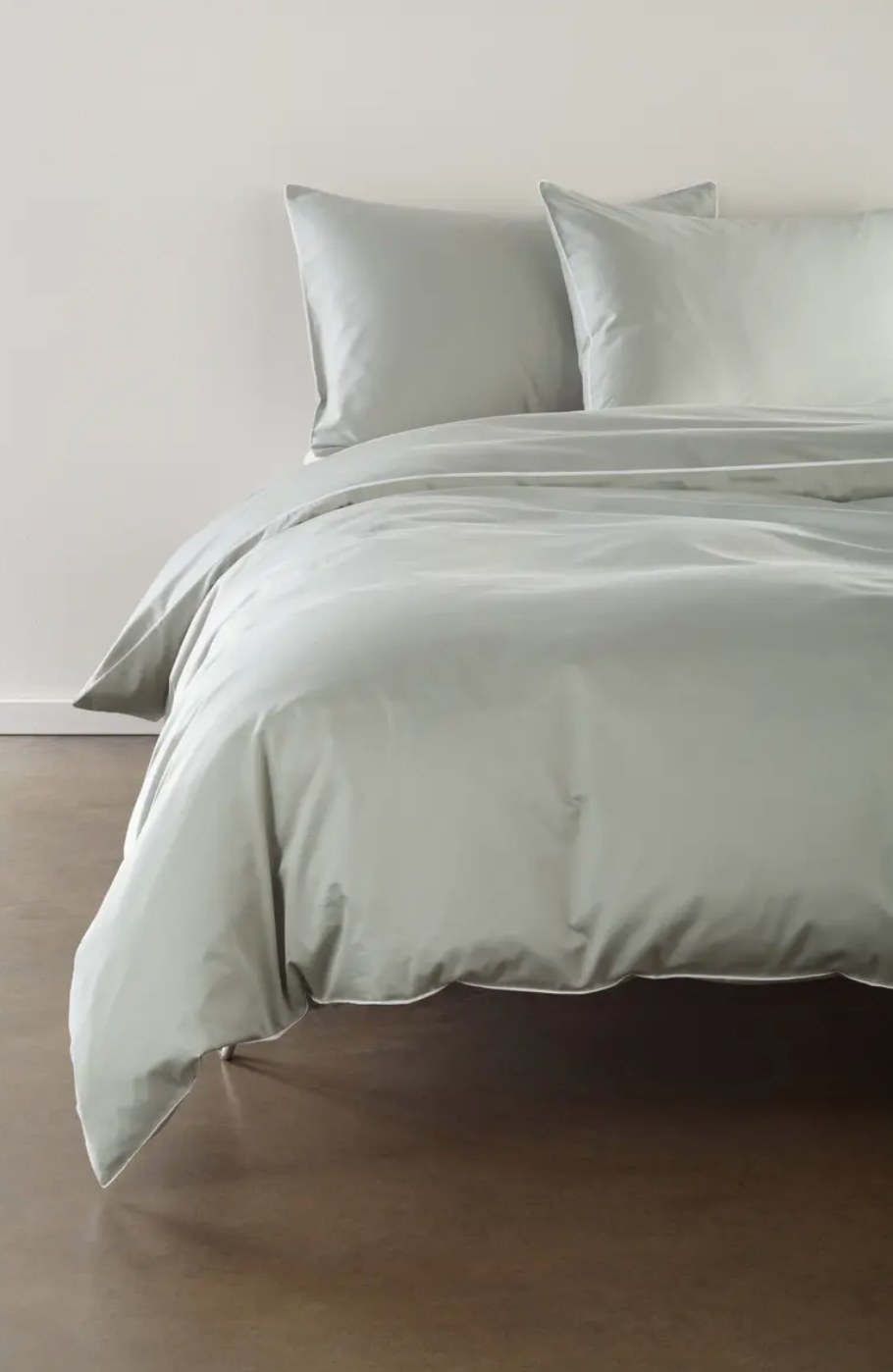 the light gray duvet and sham set on a bed
