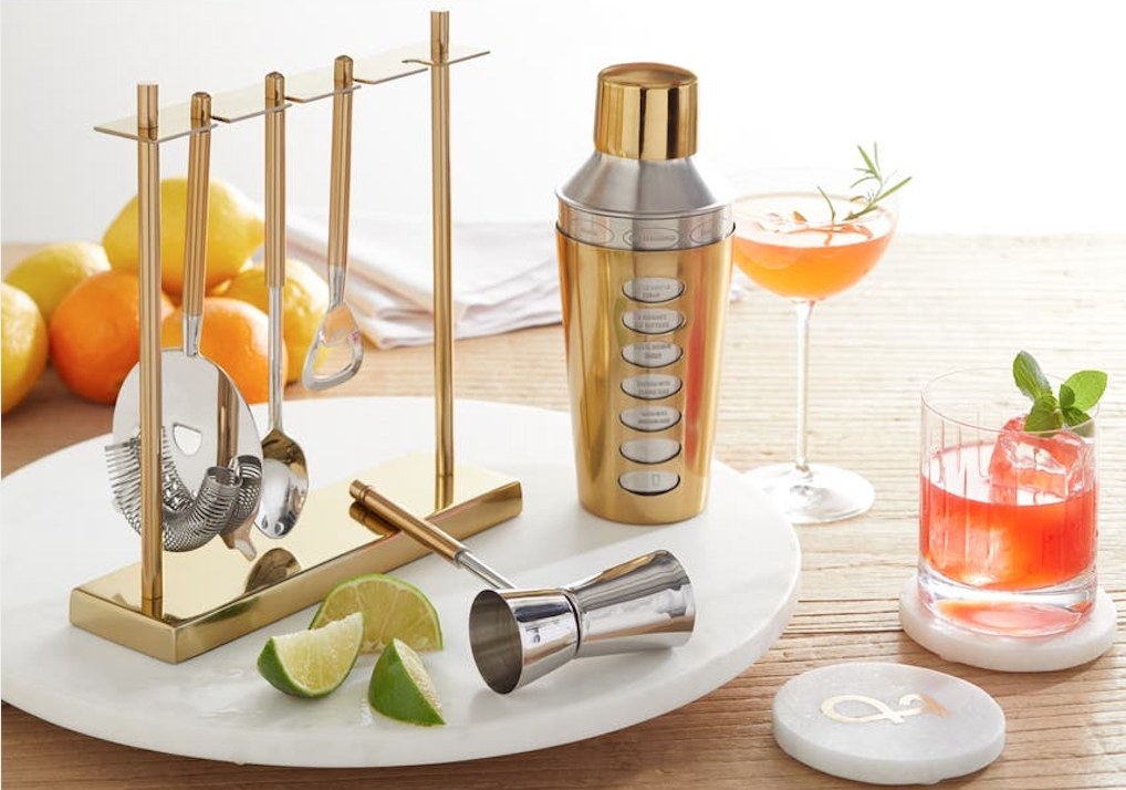 the white lazy susan tray with a cocktail shaker and other accessories on it