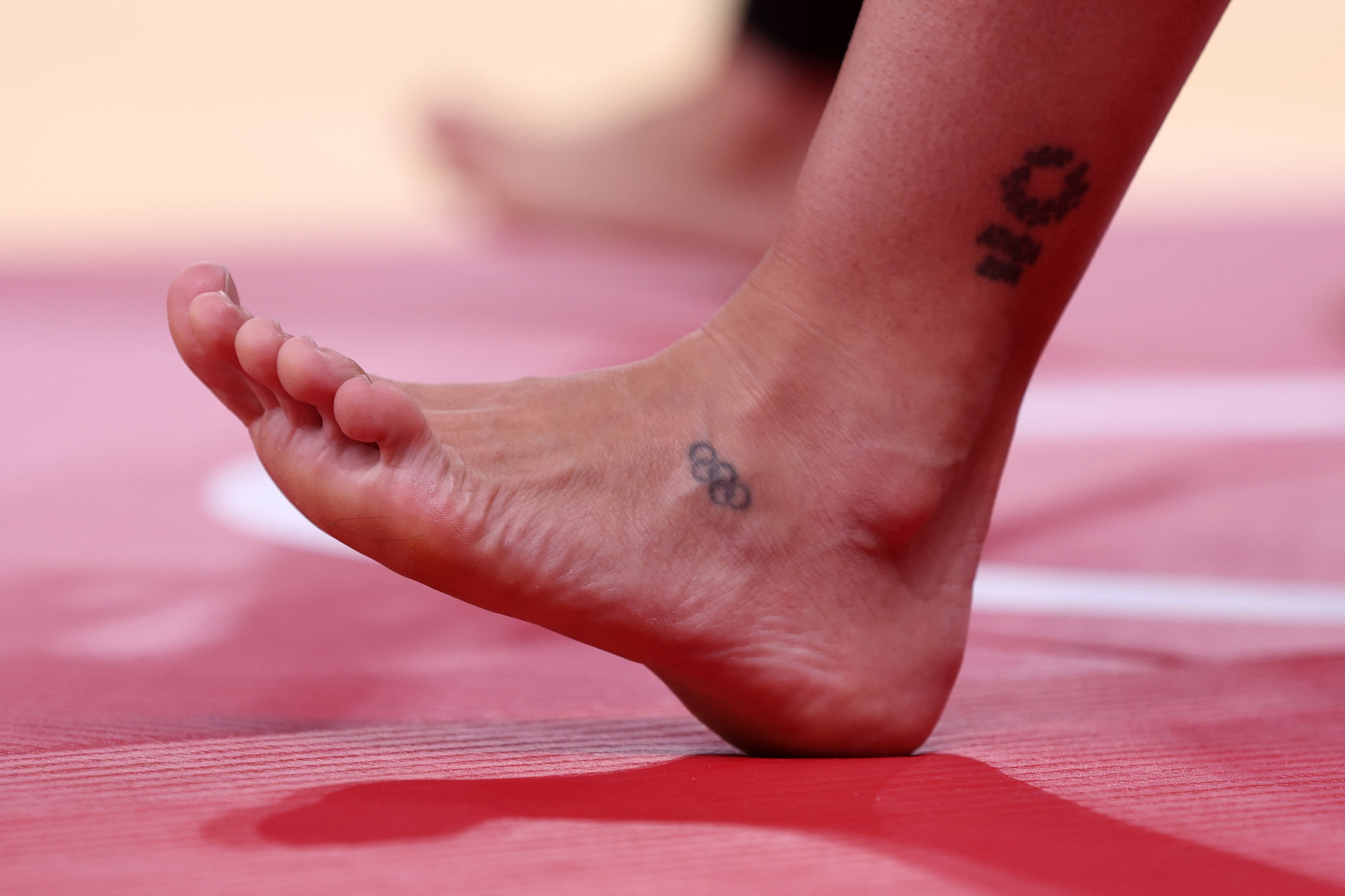 The foot of a judo athlete shows tiny Olympic rings tattoo
