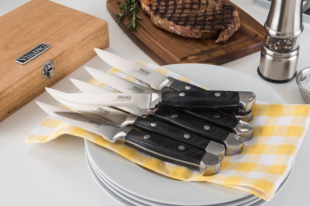 the six knives on a yellow and white checkered napkin