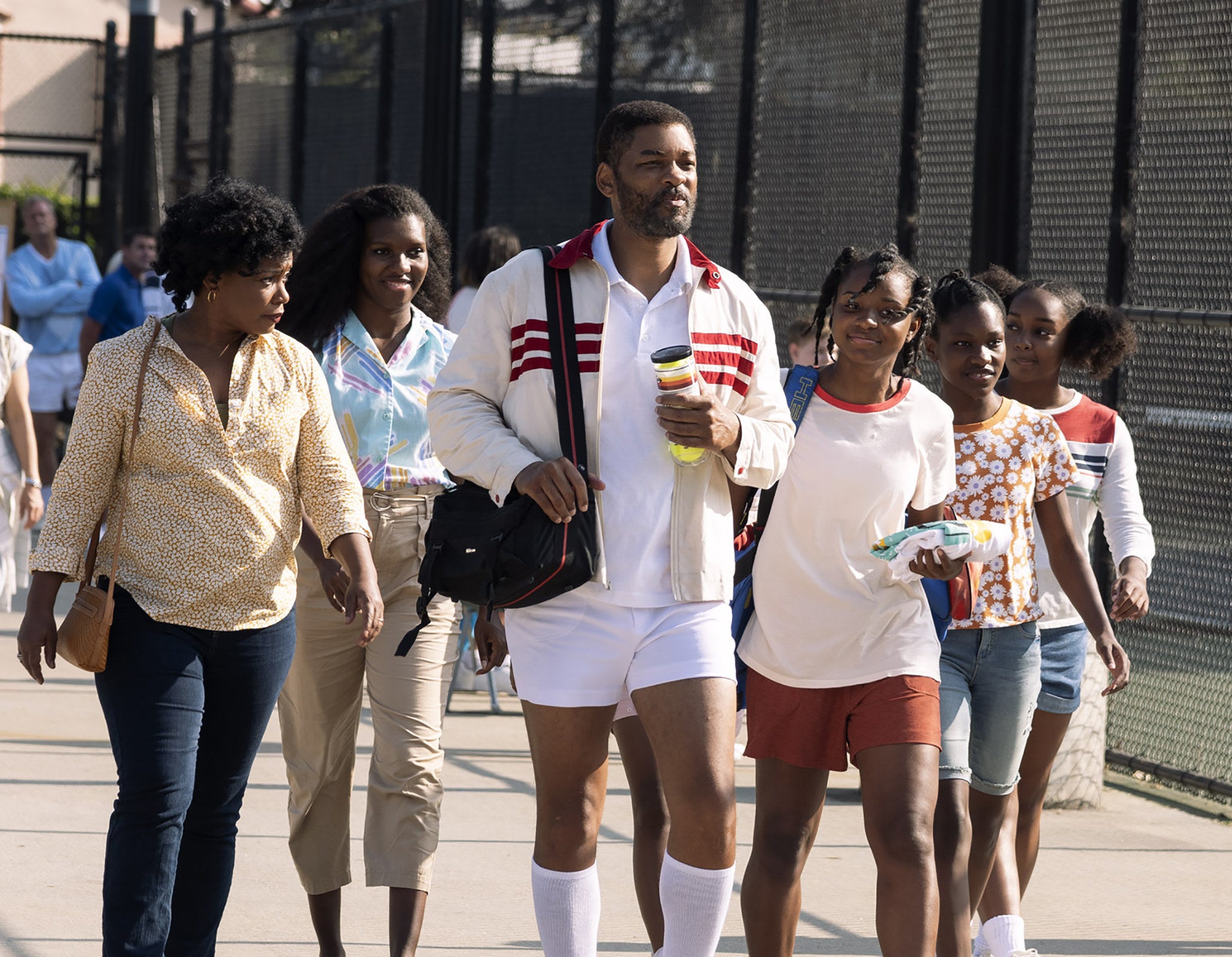 The family walking by tennis courts