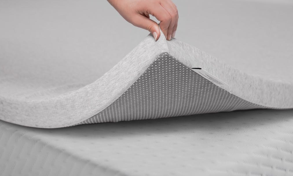 product image of someone raising up the mattress topper