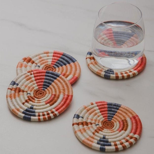 Round woven coasters that are red, blue, orange, and salmon