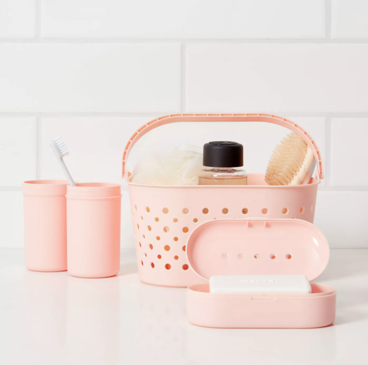 The bath caddy set in peach with some toiletries inside