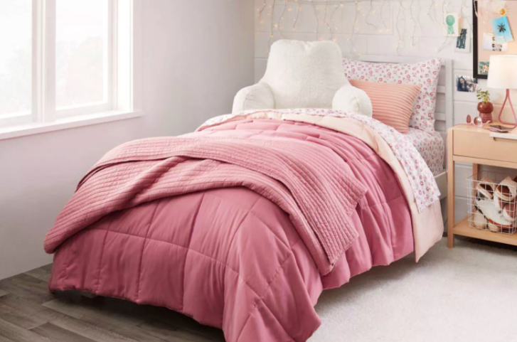The pink and peach reversible comforter on a bed