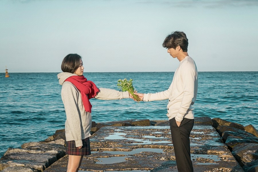 Woman handing man flowers