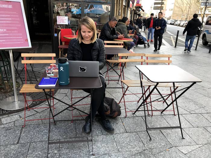 Woman on her computer in front of a café