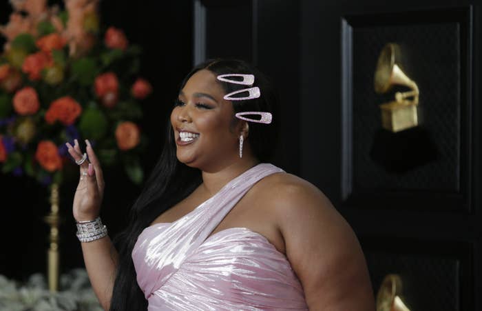 Lizzo is pictured waving on the red carpet at the Grammy Awards in 2021