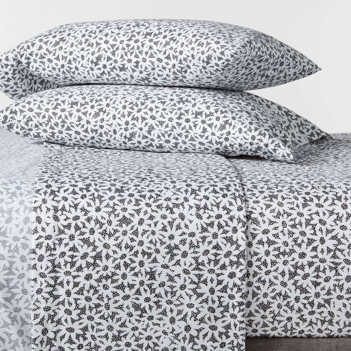 Black and white daisy printed sheets set on a bed