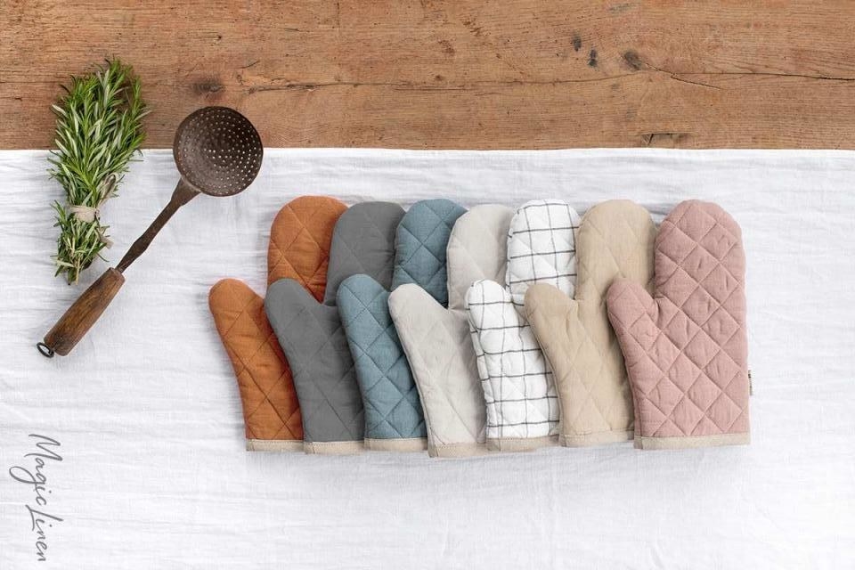 seven linen oven mitts of different colors