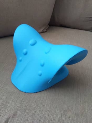 reviewer image of the blue neck and shoulder relaxer on a couch