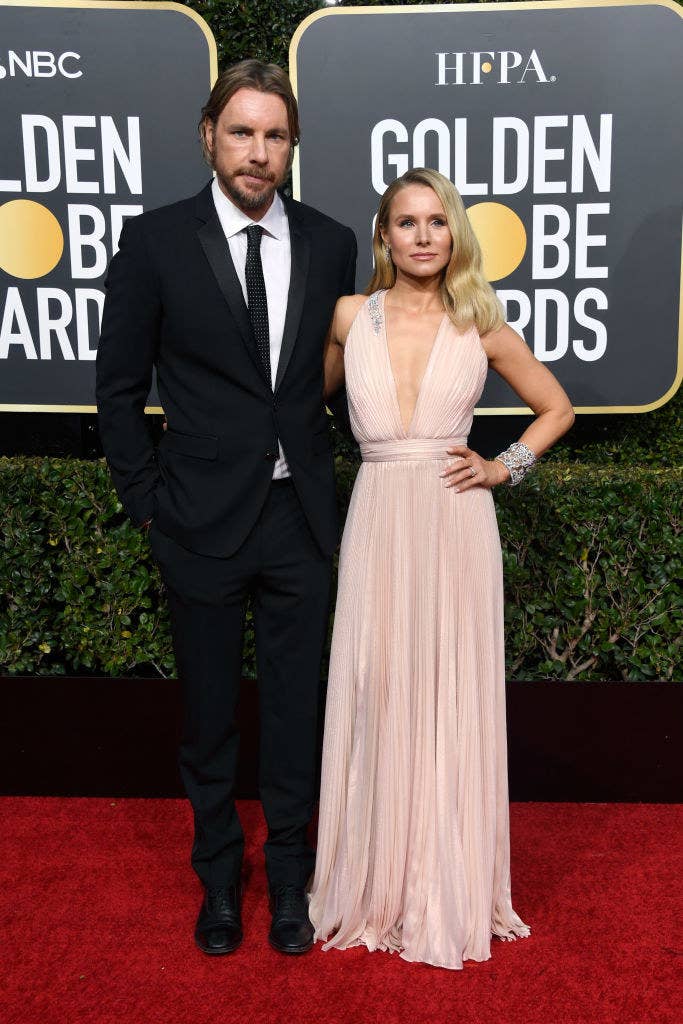 Dax and Kristen posing on the Golden Globes red carpet in a suit and low-cut gown, respectively