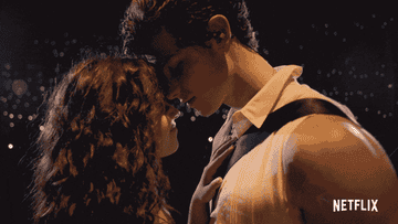 GIF of Camila and Shawn standing close and touching noses