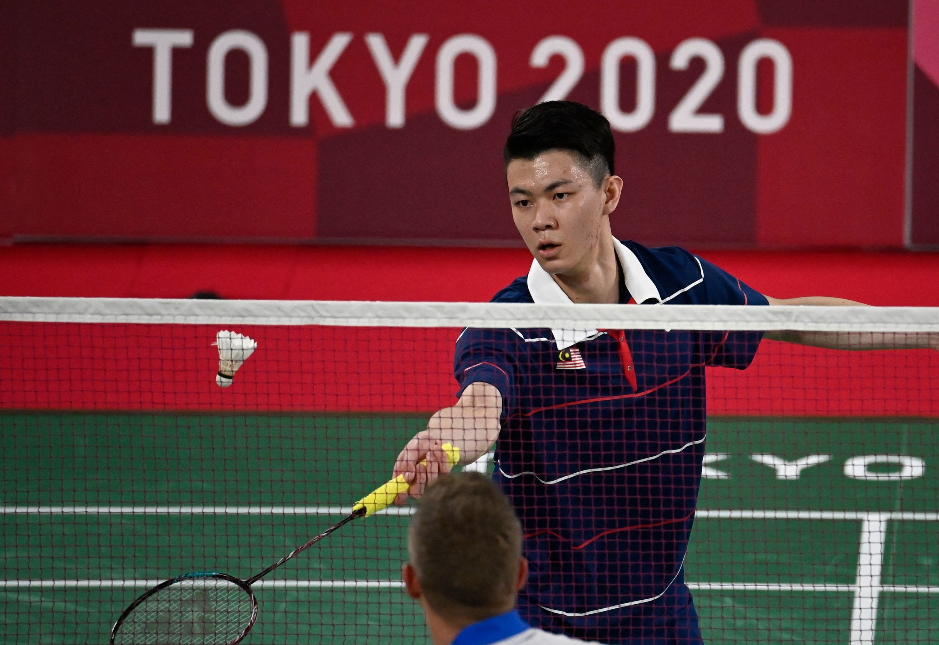 A Malay badminton player hitting a shot while playing