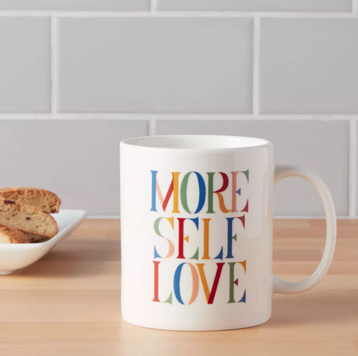 White coffee mug that says &quot;More self love&quot; in multicolored letters