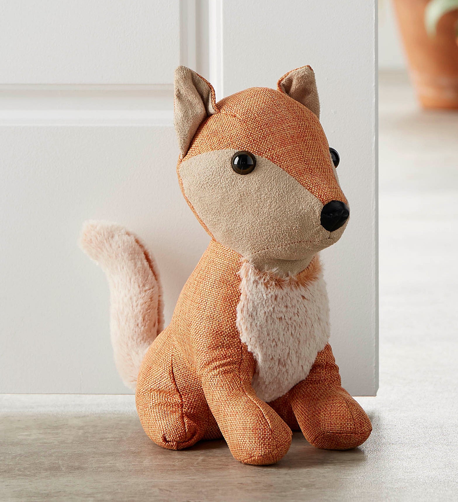 a fox shaped door stopper holding a door open