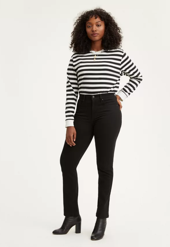 model wearing a pair of black straight jeans with a black and white striped shirt and black heeled booties