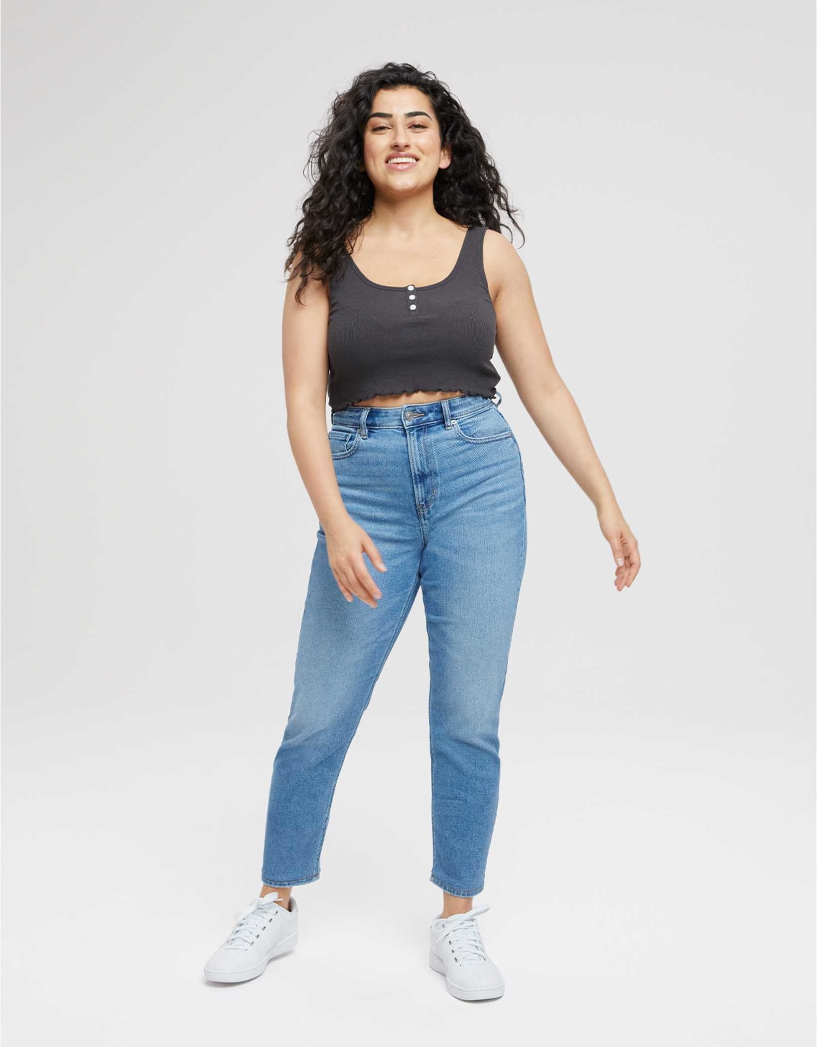 model wearing light wash jeans with tapered leg and a high waist