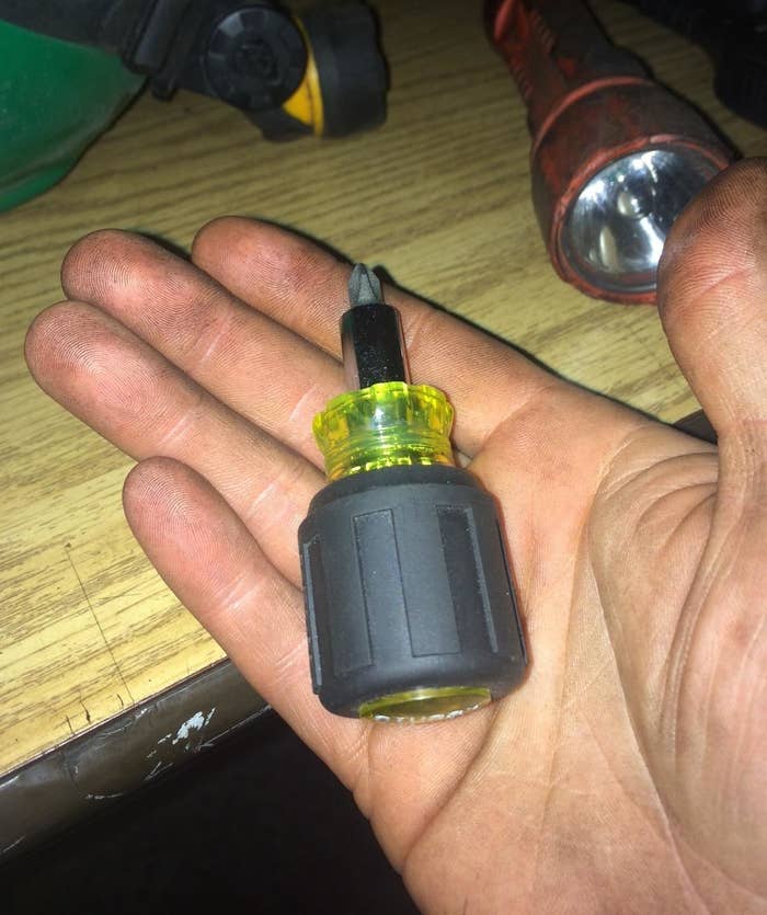 The green and gray screwdriver in a reviewer&#x27;s hand.