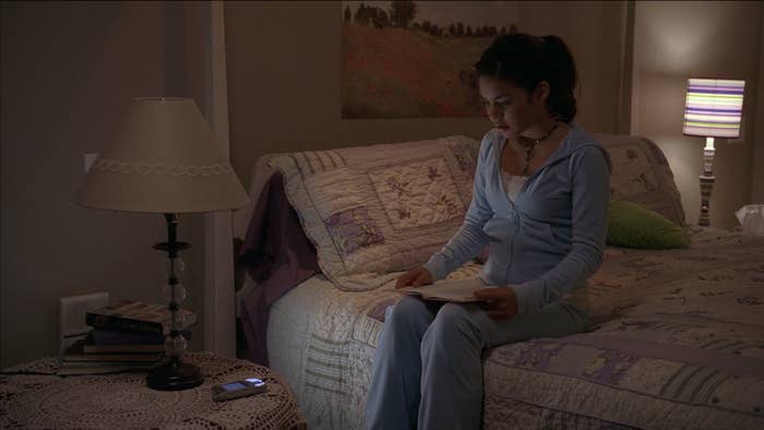 Gabriella sits in her room reading a book